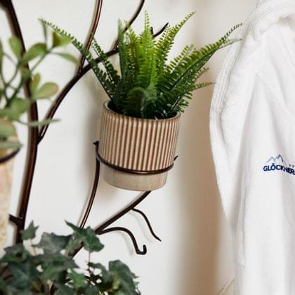 White bathrobe with Glocknerin logo hanging next to wall-mounted plants